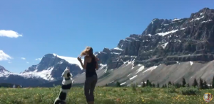 Sara Carson dancing with Hero the Super Collie in front of Canadian Mountains
